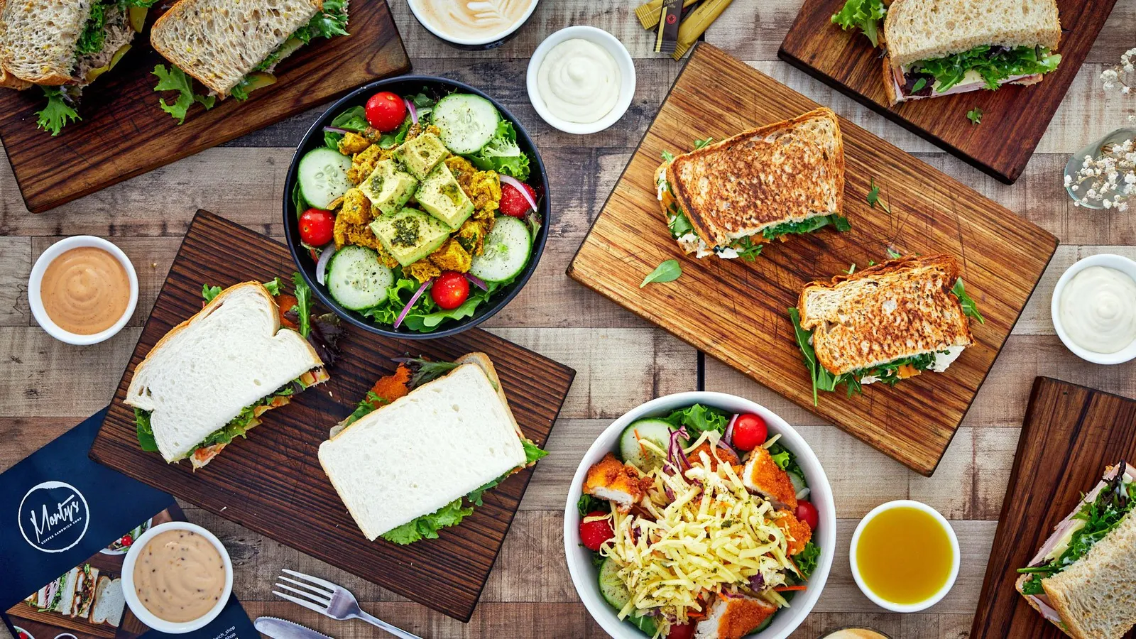 Office lunch platter from Monty's, sandwiches cut in halves and salads on wooden boards